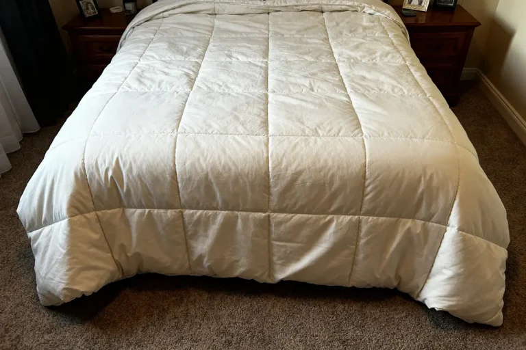 Lit avec couette blanche illustrant la taille de housse de couette sur moquette beige